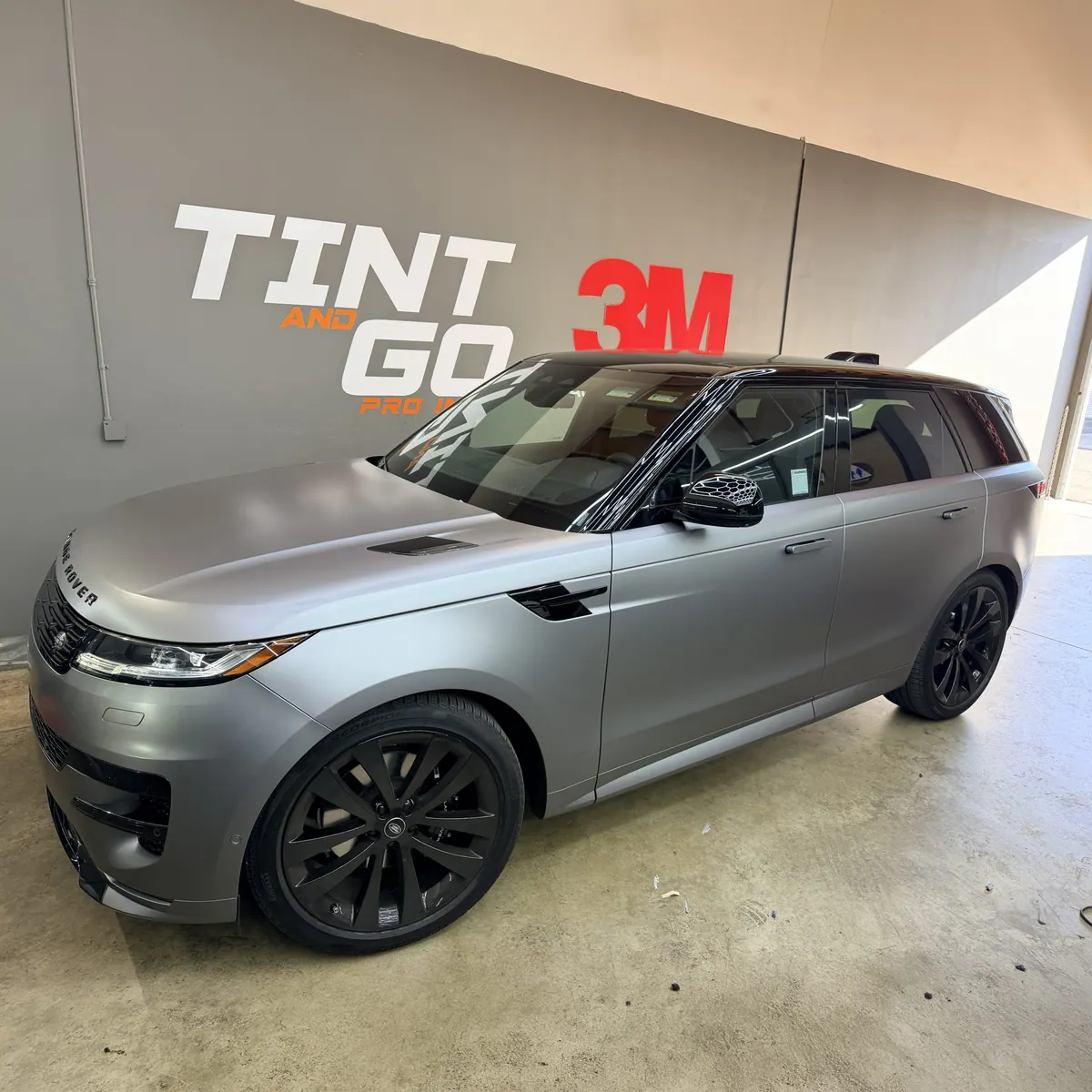Range Rover Sport in a satin silver finish with black wheels inside the Tint & Go Pro bay