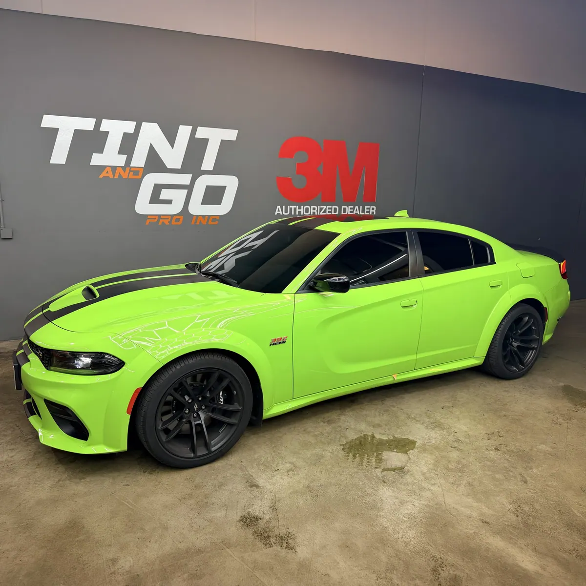 Lime green Dodge Charger with tinted windows inside the Tint & Go Pro studio